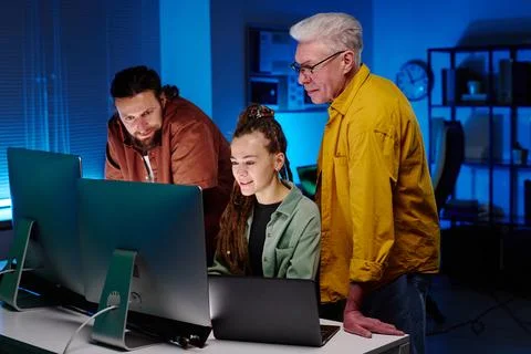 Group of IT engineers looking at screen of desktop computer Stockfoto's