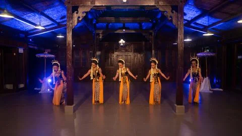 A group of Javanese dancers in traditional patterned costumes dance with th.. Foto stock