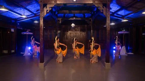 A group of Javanese dancers in traditional patterned costumes dance with th.. Foto stock