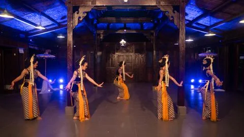 A group of Javanese dancers in traditional patterned costumes dance with th.. Stock Photos