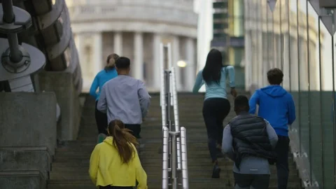 Group of joggers run up some steps before celebrating at the top Stock Footage 108681318