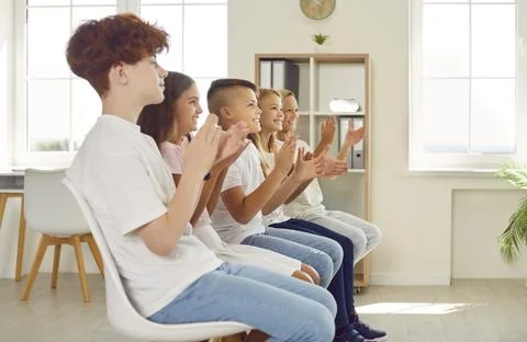 Group of junior high school students joyfully applauds after interesting Stock Photos