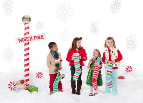 Group of kids (18-23months, 4-5,6-7) standing next to North Pole sign Stock Photos