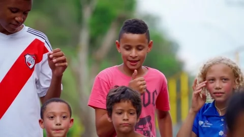 Group of kids posing for a photo with one spitting on the street in Brazil Stock Footage 307574910