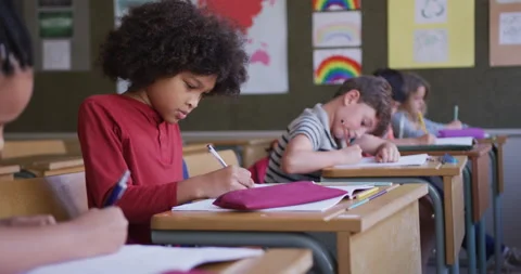 Group of kids writing while sitting on their desk in class at school 库存影片 139513981