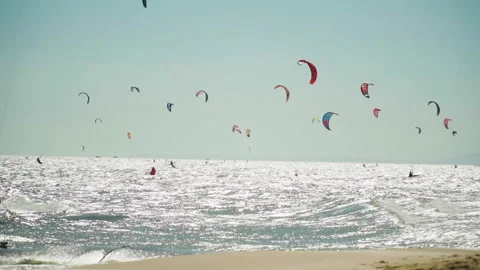 Group of Kite Surfers Flying Over Sandy Beaches and Ocean with Clear Blue Stock Footage 161170698