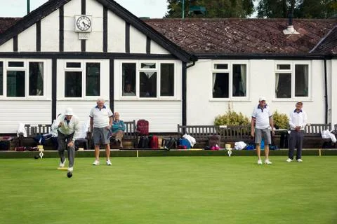 A group of lawns bowls players by a clubhouse, preparing for play. Stock Photos