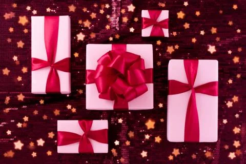A group of light pastel pink boxes tied with a red satin ribbon with a bow of Stock Photos
