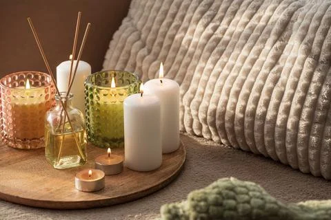 Group of lit candles and diffuser sticks arranged on a wooden tray with tex.. Stock Photos