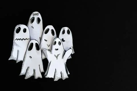Group of little ghosts playing at scaring. Paper cut out with black backgroun Illustrazione stock