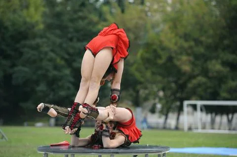 Group of little girls acrobats doing acrobatic tricks on a football field Stock Photos