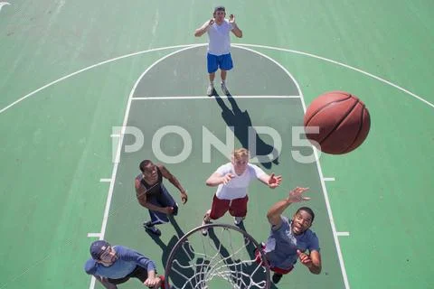 Group Of Male Friends Playing Basketball On Outdoor Court, Elevated View