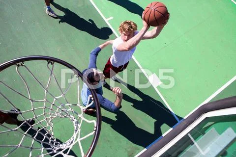 Group Of Male Friends Playing Basketball On Outdoor Court, Elevated View