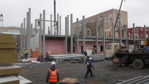 A group of male workers in yellow jackets and helmets is on the construction Stock Footage 132201512