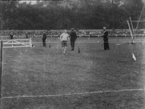 Group of man runners running on stadium with audience cheering, UK, 1902 Stock Footage 136678826