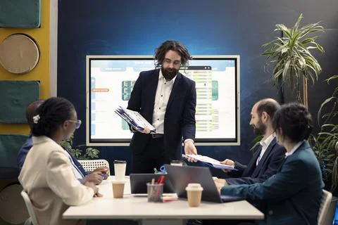 Group manager distributes papers with current statistics on performance Foto stock