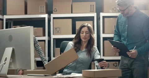 Group of managers prepare parcels for shipment and bring cardboard boxes to Video stock 150390993
