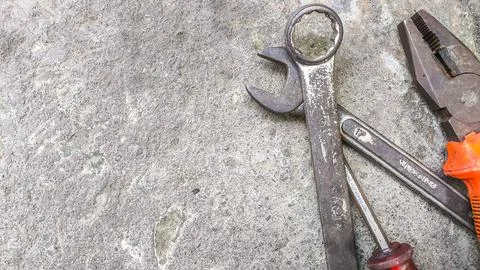 Group of manual tools placed randomly on a textured cement base. Background.. Stock Photos