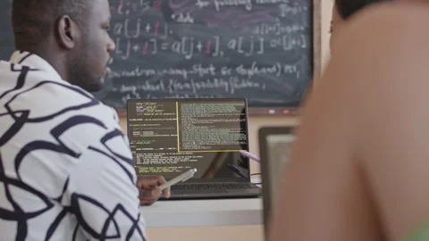 Group Mates Discussing Programming Code on Laptop Stock Footage 257067500