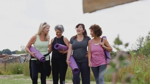 Group Of Mature Female Friends On Outdoor Yoga Retreat Walking Along Path Stock Footage
