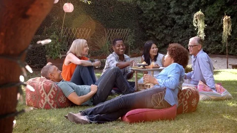 Group Of Mature Friends Enjoying Picnic In Backyard Together Stock Footage
