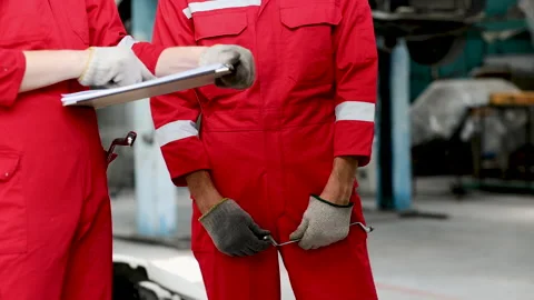 Group of mechanics consulting or checking a repairing a car lifting equipme.. Stock Footage 242834201