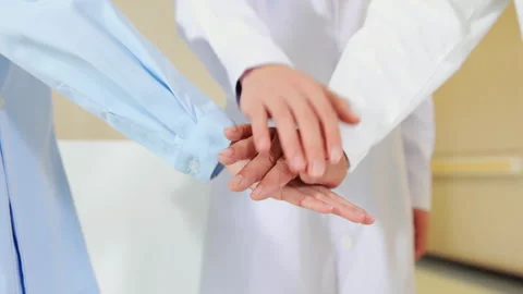 Group of medical professionals team's doctors nurses joining hands in unity Stock Footage 332375352