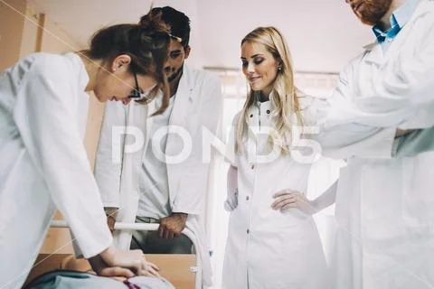 Group of medical students practicing reanimation task on model Stock Photos