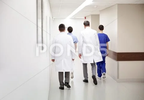 Group of medics or doctors walking along hospital Stock Photos