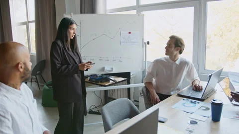 Group meets in office to share ideas and review financial reports. They 스톡 동영상 335731388