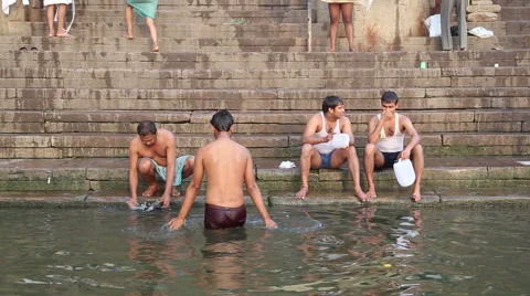 Group of men bathing and sitting at ghat of Ganges river in Varanasi. Stock Footage 50546509