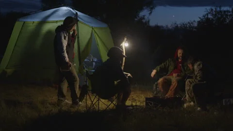 Group of men camping in the wild and gather near the bonfire and talk with each 動画素材 338039029