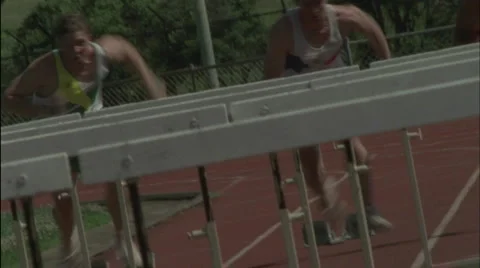A group of men jump hurdles on a running track. Vídeos de archivo 5089697