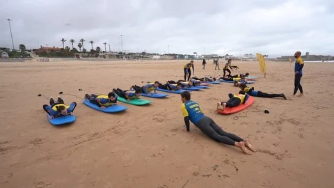 Group of men learning how to surf Stock Footage 124146562