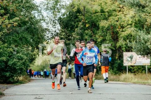 Group men of middle age runners running in autumn Park Stock Photos