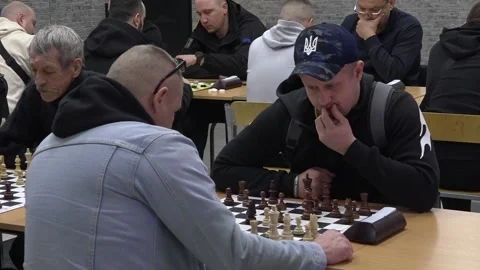 A group of men play chess during a tournament at a chess club. Medium Shot Stock Footage 332084583