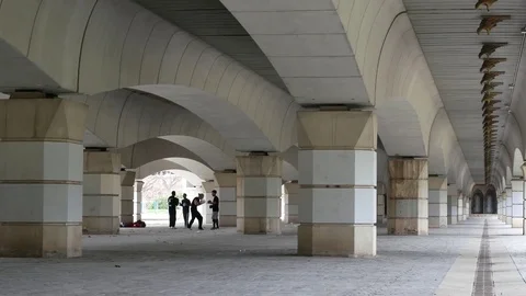 A group of men practicing karate in the background under a bridge. Stock Footage 75308944