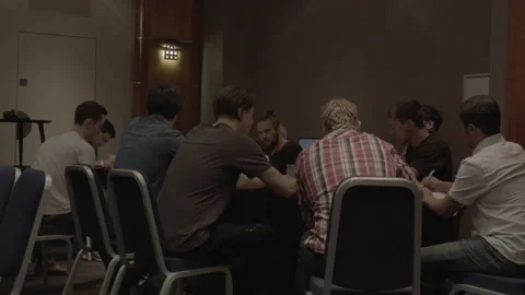 Group of men sitting around a table during a business meeting or workshop Stock Footage 342564989