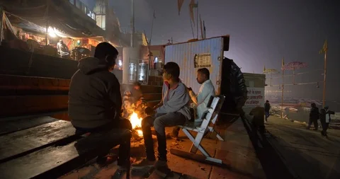 A group of men sitting close to a campfire at night in Varanasi Stock Footage 122409632