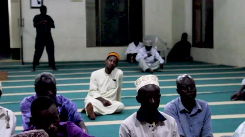 A group of men sitting on the floor inside a mosque, listening attentively Stock Footage 345835101