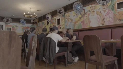 Group of men sitting at a table in a Mexican restaurant Stock Footage 342564099