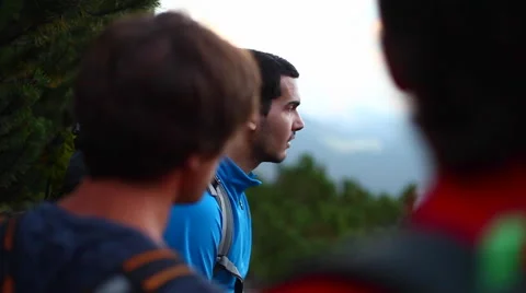 A group of men take a break from hiking to look at the view. Stock Footage 68578943