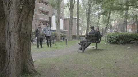 Group of men talking during an outdoor video shoot in a park Stock-Footage 342564017