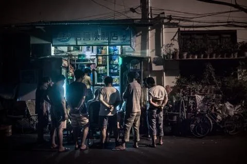 A group of men watch a TV program on the street in Shanghai Stock Photos