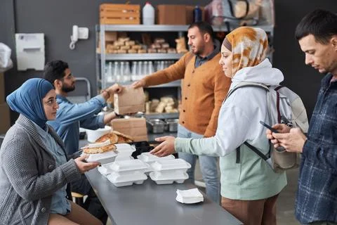 Group Of Middle Eastern People Standing in Line at Soup Kitchen Stock Photos