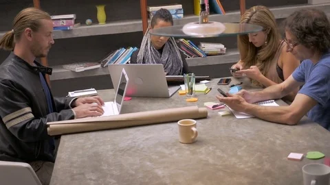 Group of millennials working on their computers and phones in an office space Stock Footage