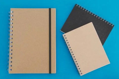 Group of minimalist looking notebooks of different shapes on blue Stock Photos