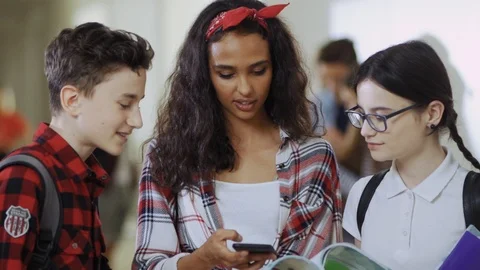 Group of miscellanous teen students using a smartphone looking through Stock Footage 113283492