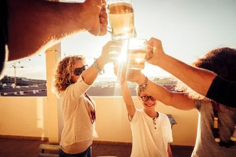 Group of mixed ages and generations toast together with beer and fruits juice Foto stock
