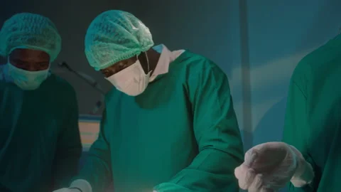 Group of mixed-races professional surgeons operating in hospital operating ro Stockbeeldmateriaal 195207369